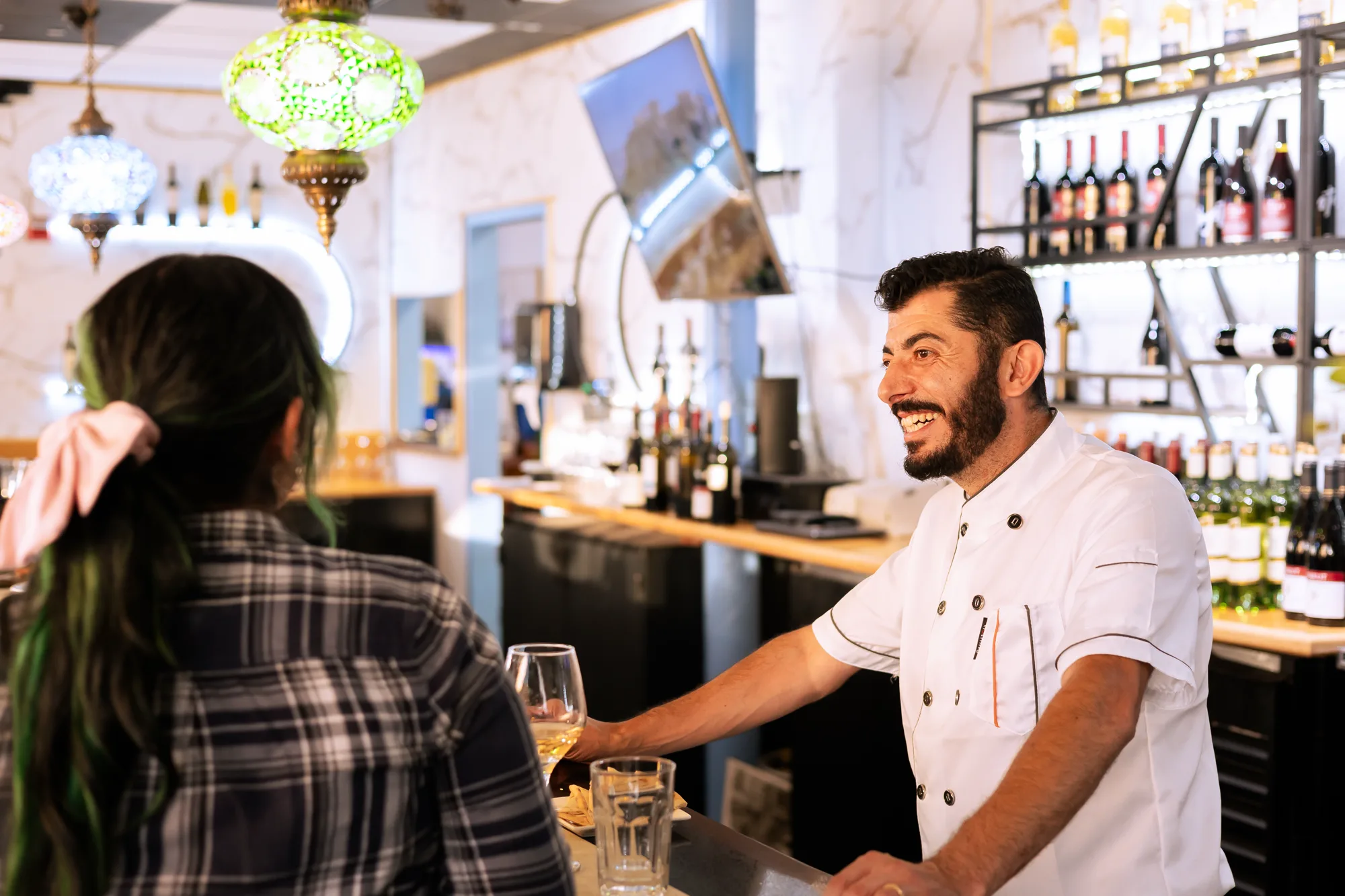 Kalimera owner serving a guest at the bar