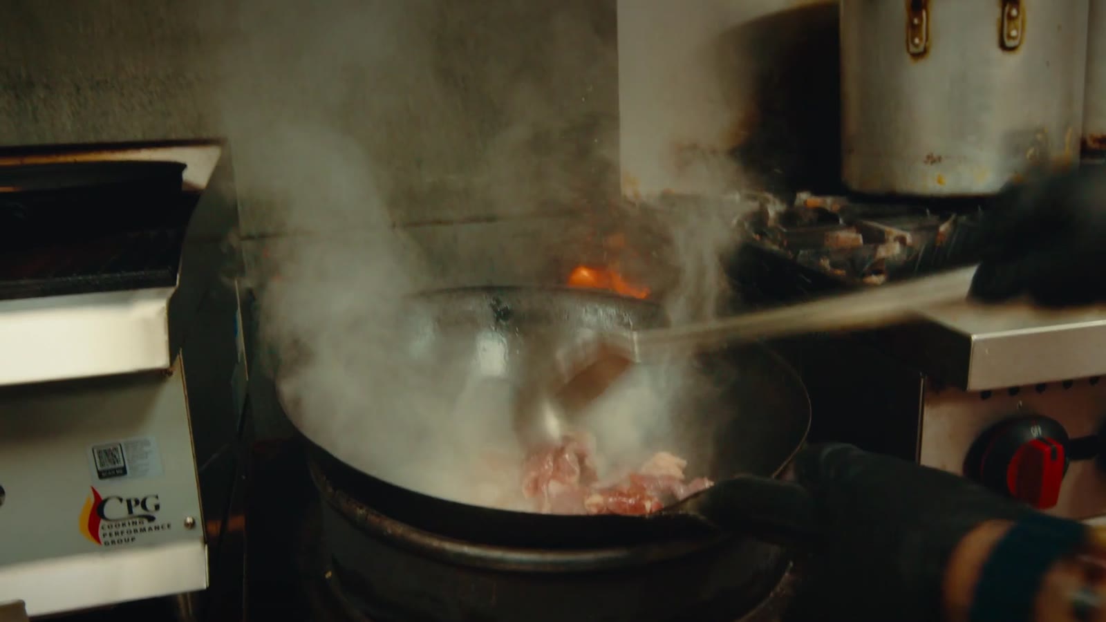 Tambayan chef cooking over fire during service