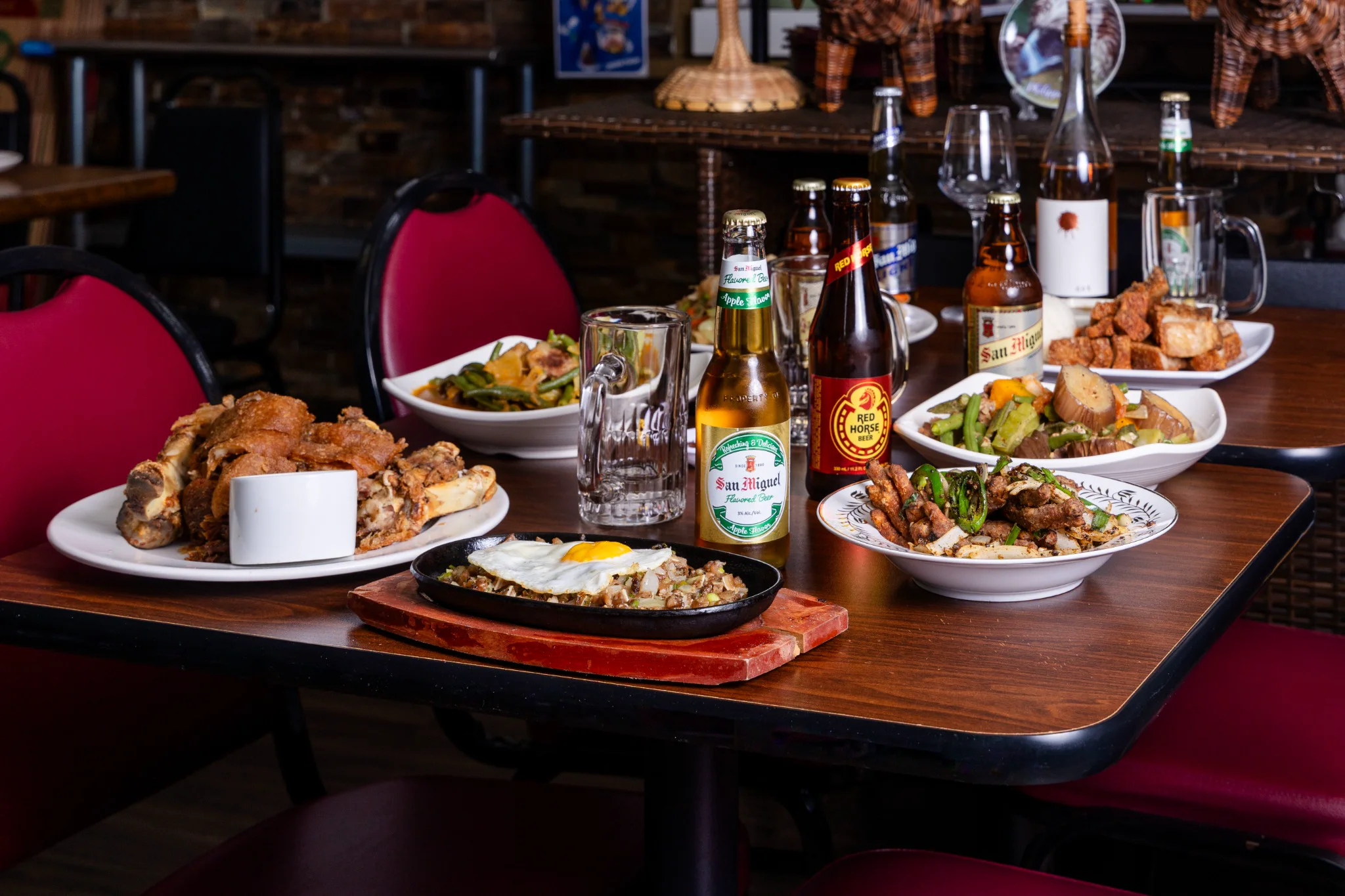 A table filled with Tambayan Filipino dishes and drinks